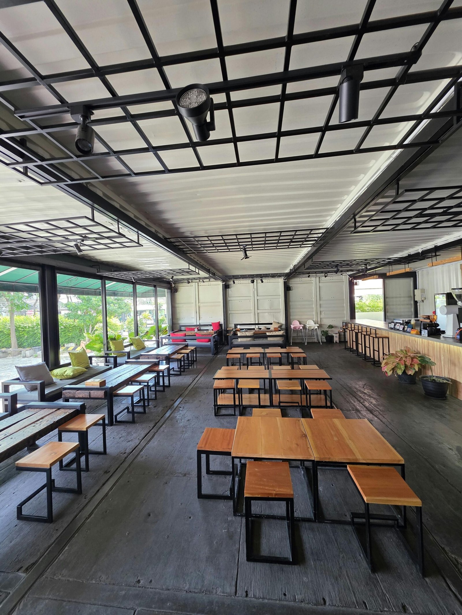 Spacious outdoor cafe with sleek wooden furniture, ideal for social gatherings.